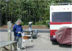 Michael using bleach spray to disinfect our hose end before hooking up our water. Notice the wire hanging across to the RV. That is our phone hookup!